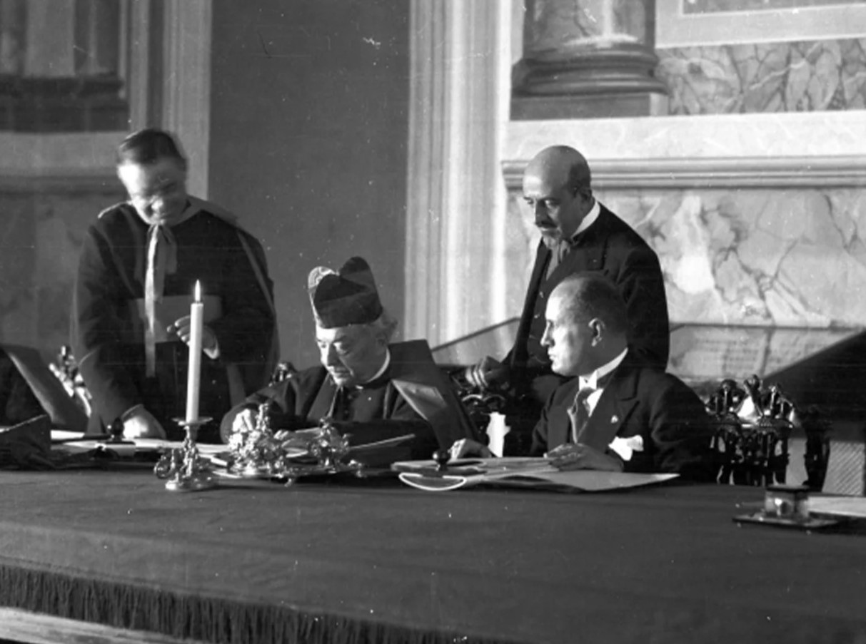 Kardinalstaatssekretär Pietro Gasparri und Ministerpräsident Benito Mussolini bei der Unterzeichnung der Lateranverträge im Lateranpalast