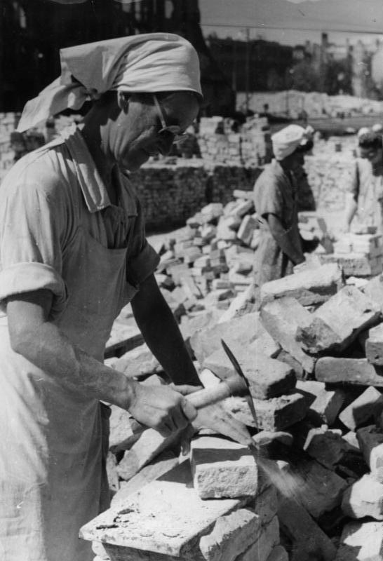 Eine Trümmerfrau im zerstörten Berlin der Nachkriegszeit