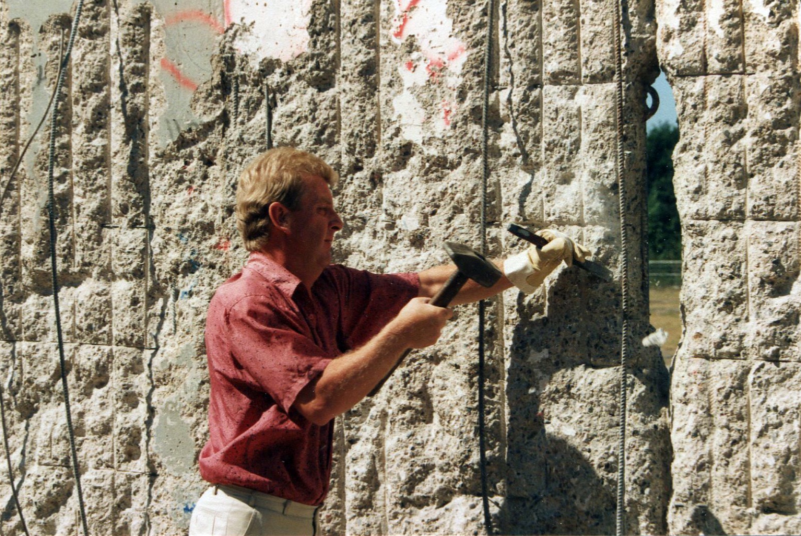 Ein „Mauerspecht" schlägt sich ein Souvenir aus der Berliner Mauer, Oktober 1990